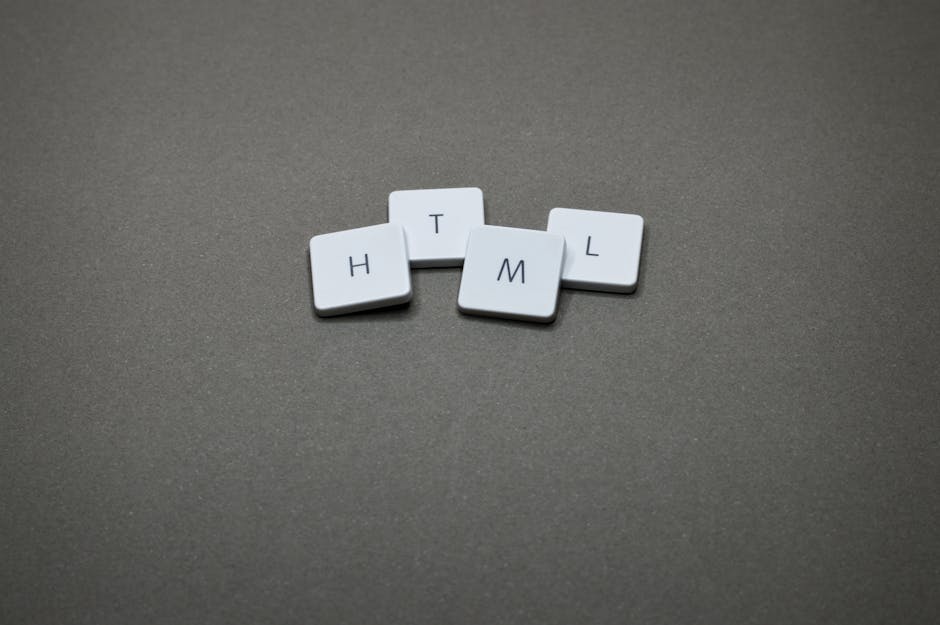 A close-up of four white keyboard keycaps arranged horizontally on a pink background, spelling out 'HTML.' The keys are evenly spaced, with black lettering, and appear clean and unused. The surface be